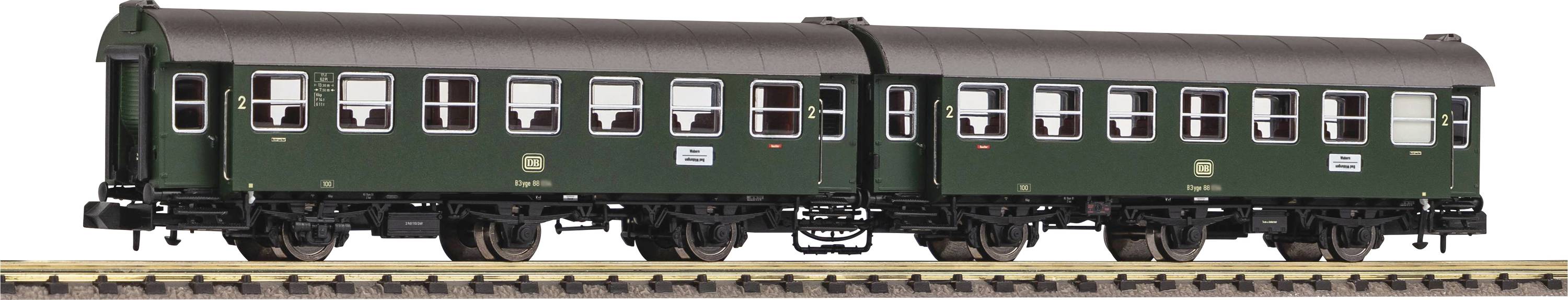 Two green passenger carriages on model railway tracks. The carriages have a classic design with multiple windows and detailed undercarriages.