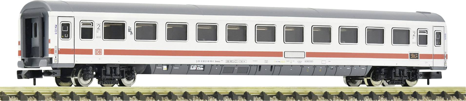A white model train passenger carriage with red stripes is standing on a track. The carriage has black window frames and grey details.