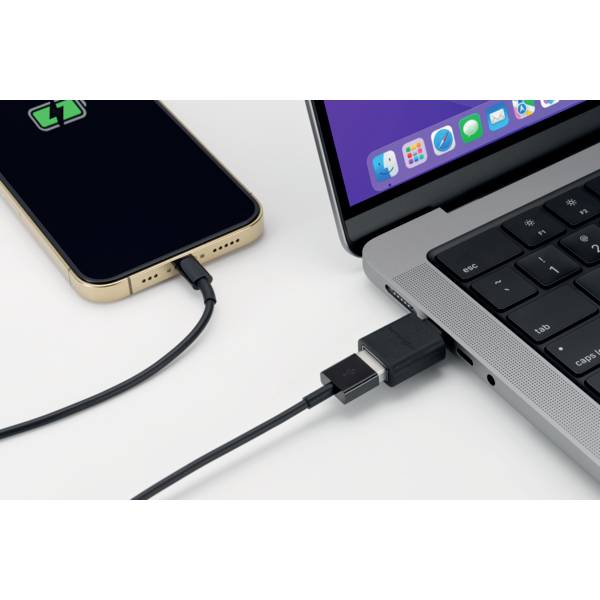 Laptop and smartphone connected by a USB-C cable. Laptop displays open applications, smartphone screen shows charging symbol.