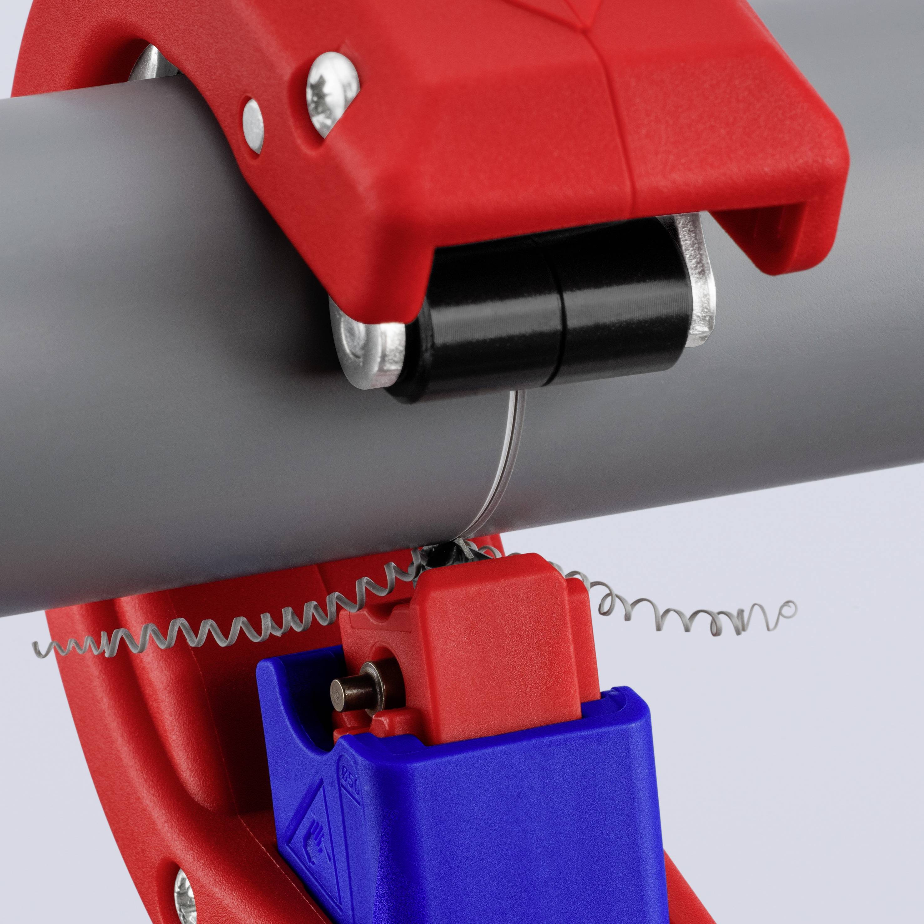A red hose clamp holding a grey hose, with a blue central piece and a small spring to control tension.