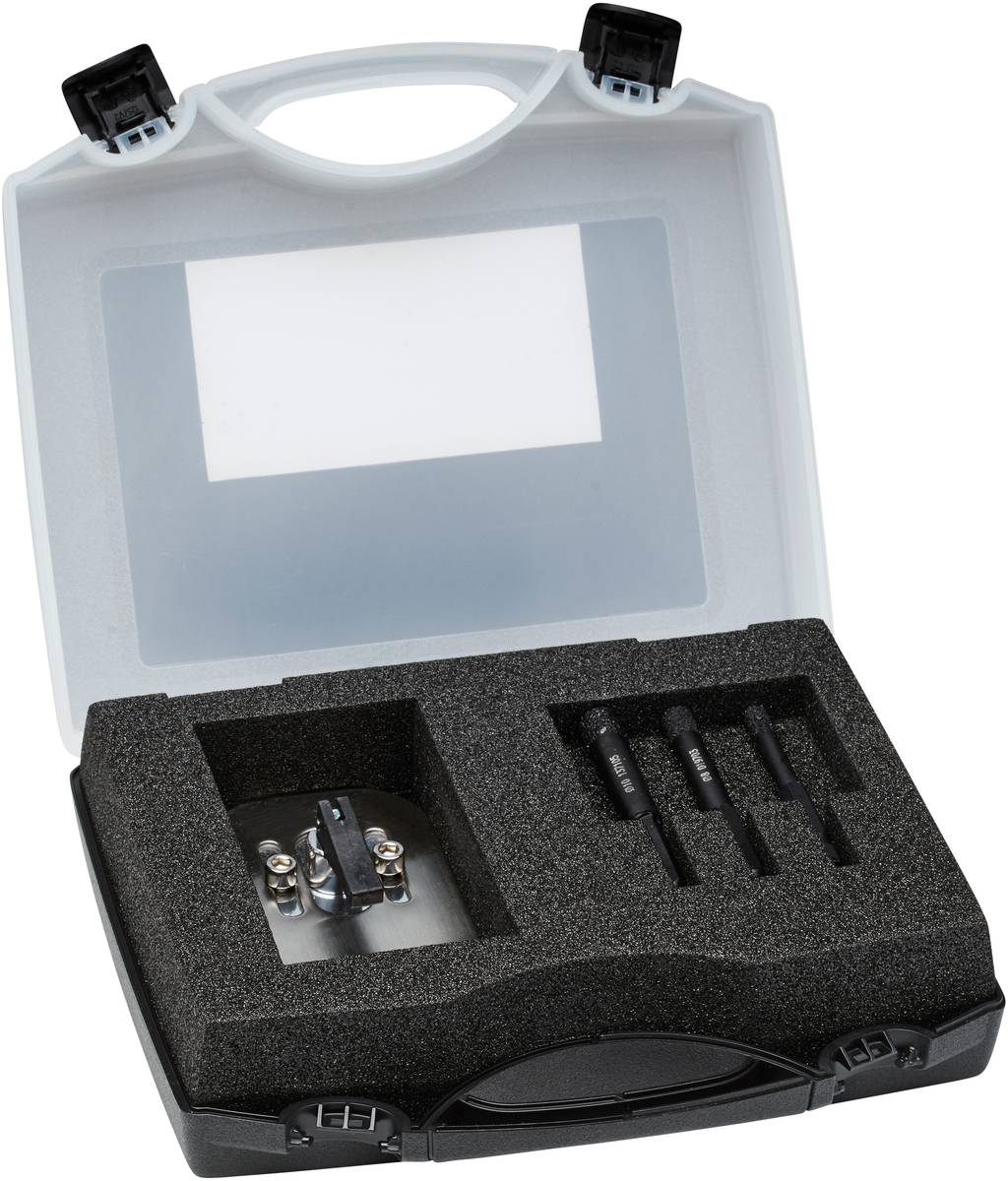 An open tool case with foam lining containing a drill and three screwdrivers.