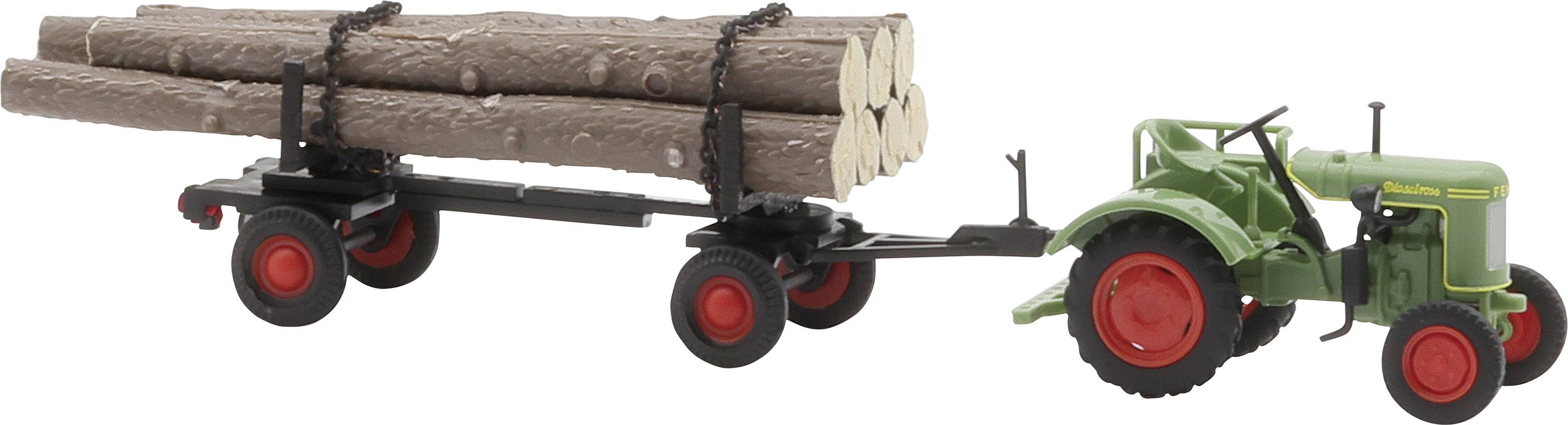 A green tractor is pulling a trailer loaded with logs. The trailer has four red wheels, and the logs are secured with chains.