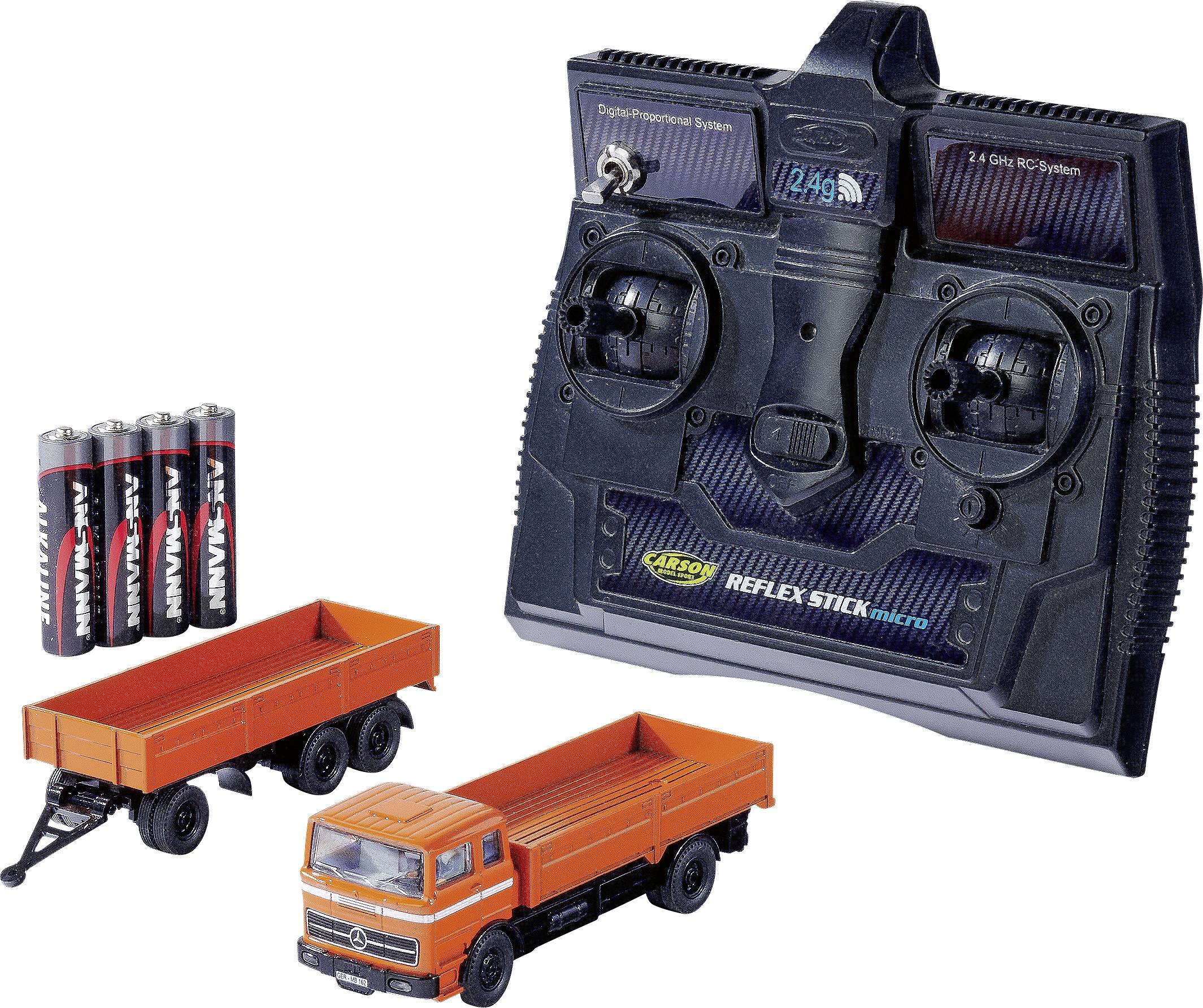 Radio control system for RC vehicles, type 'CARSON Reflex Stick Micro' next to a lorry toy and batteries.