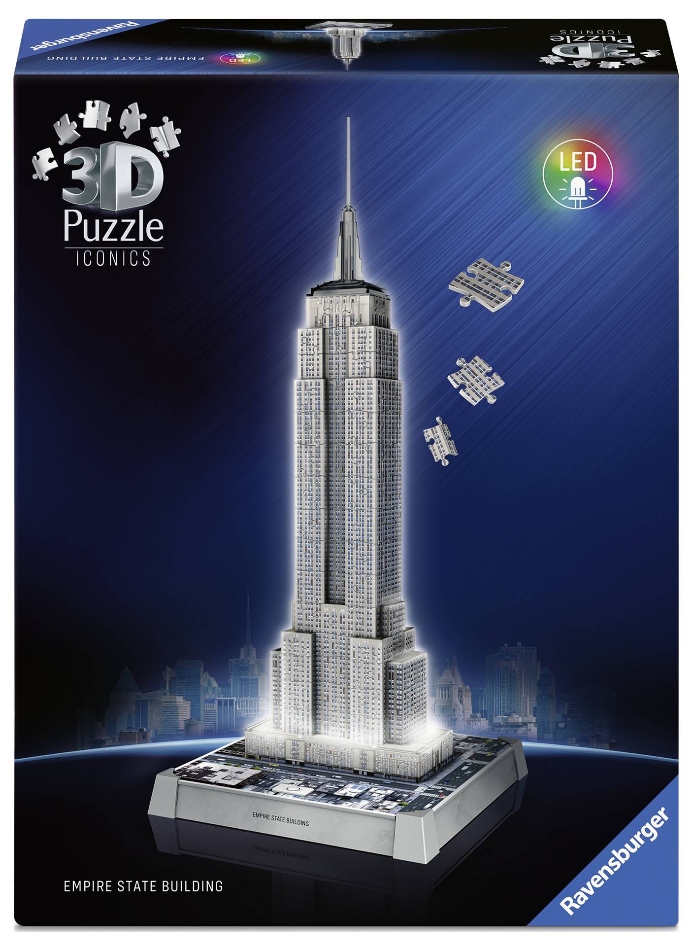 A lit 3D puzzle of the Empire State Building on a decorative base, with several small aeroplanes around the building.