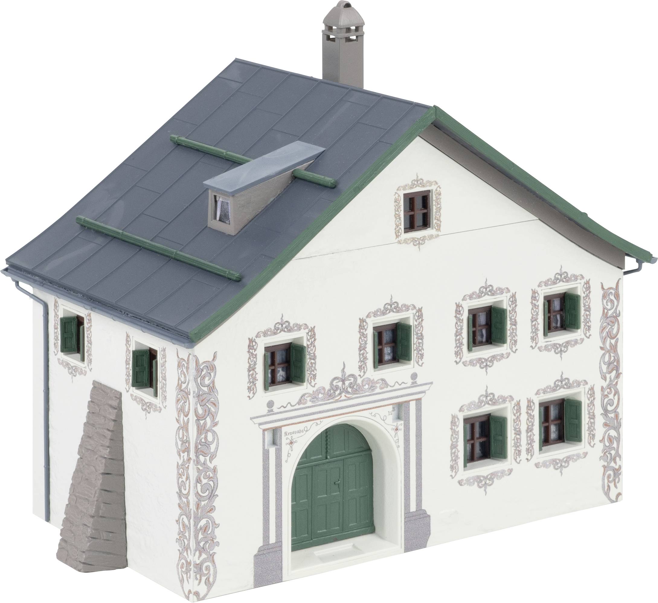 A traditional two-storey house with a grey roof, green window shutters and decorative details on the walls.