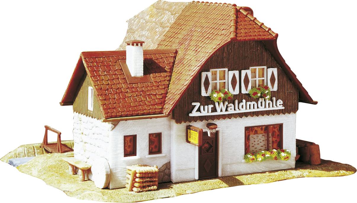 Small model building with a red roof and white walls, with the inscription 'Zur Waldmühle' on the facade.