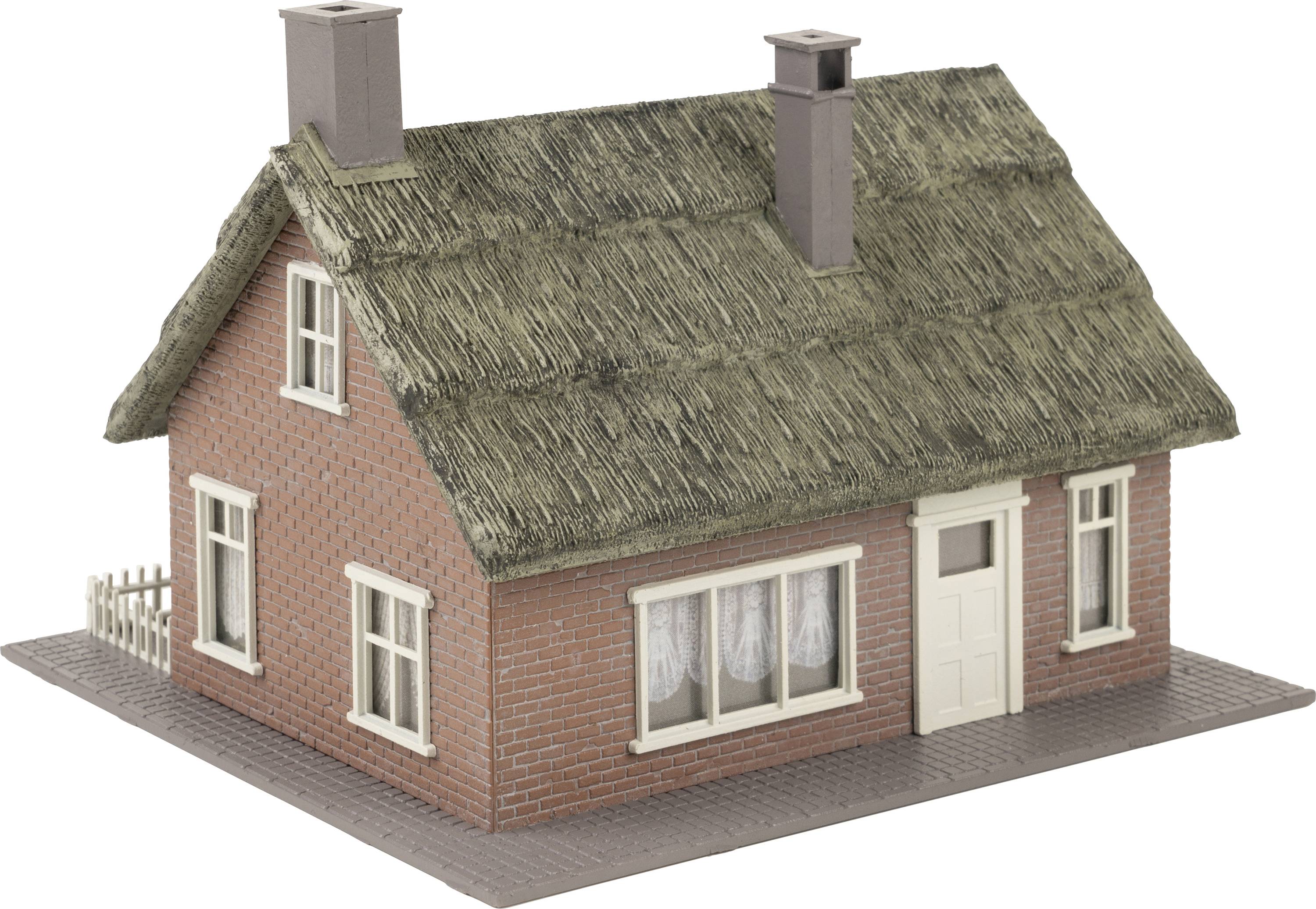A small red brick house with a thatched roof, white windows, and two chimneys.