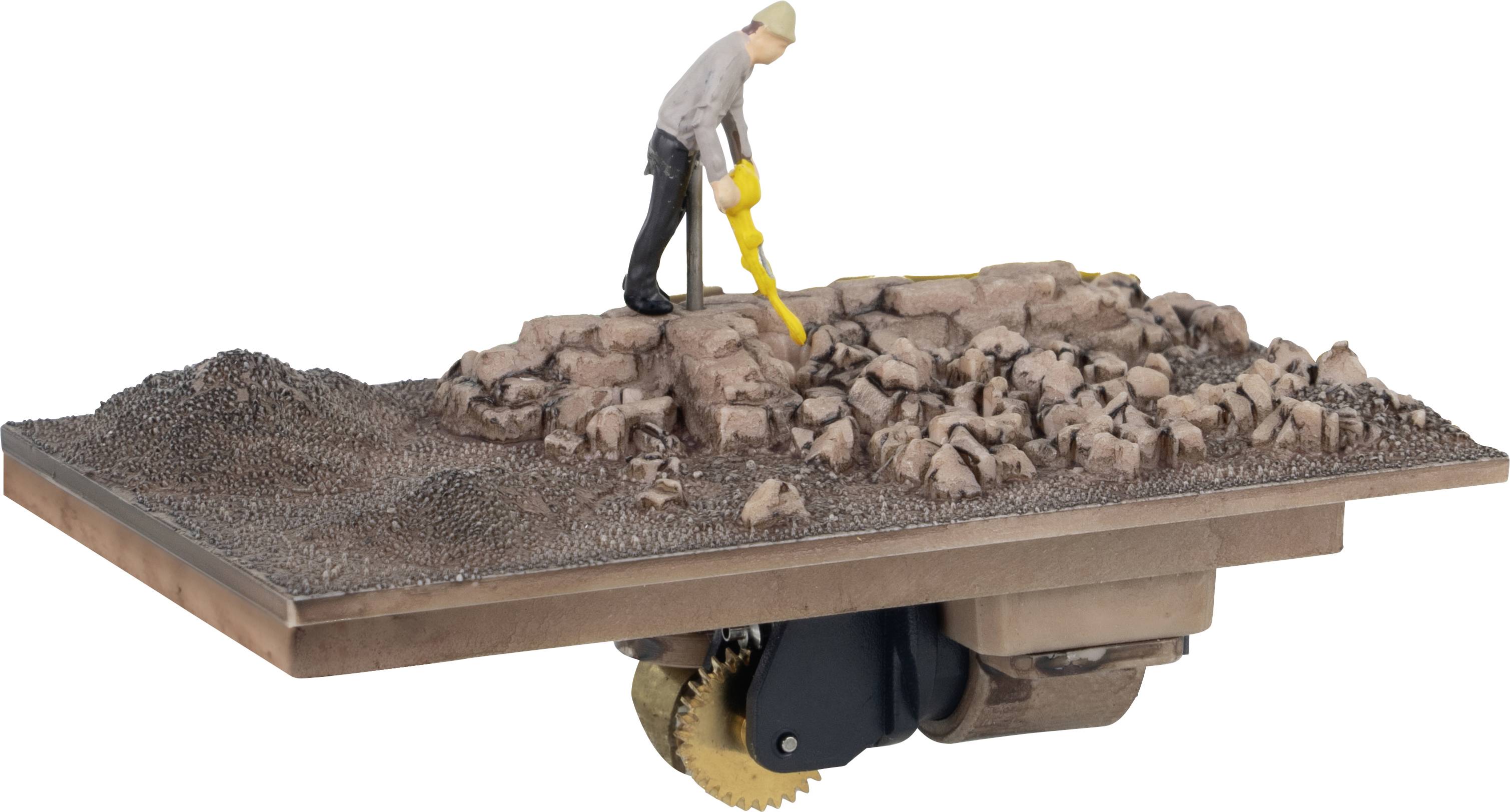 A miniature model depicts a person searching for objects with a metal detector on rocky terrain.