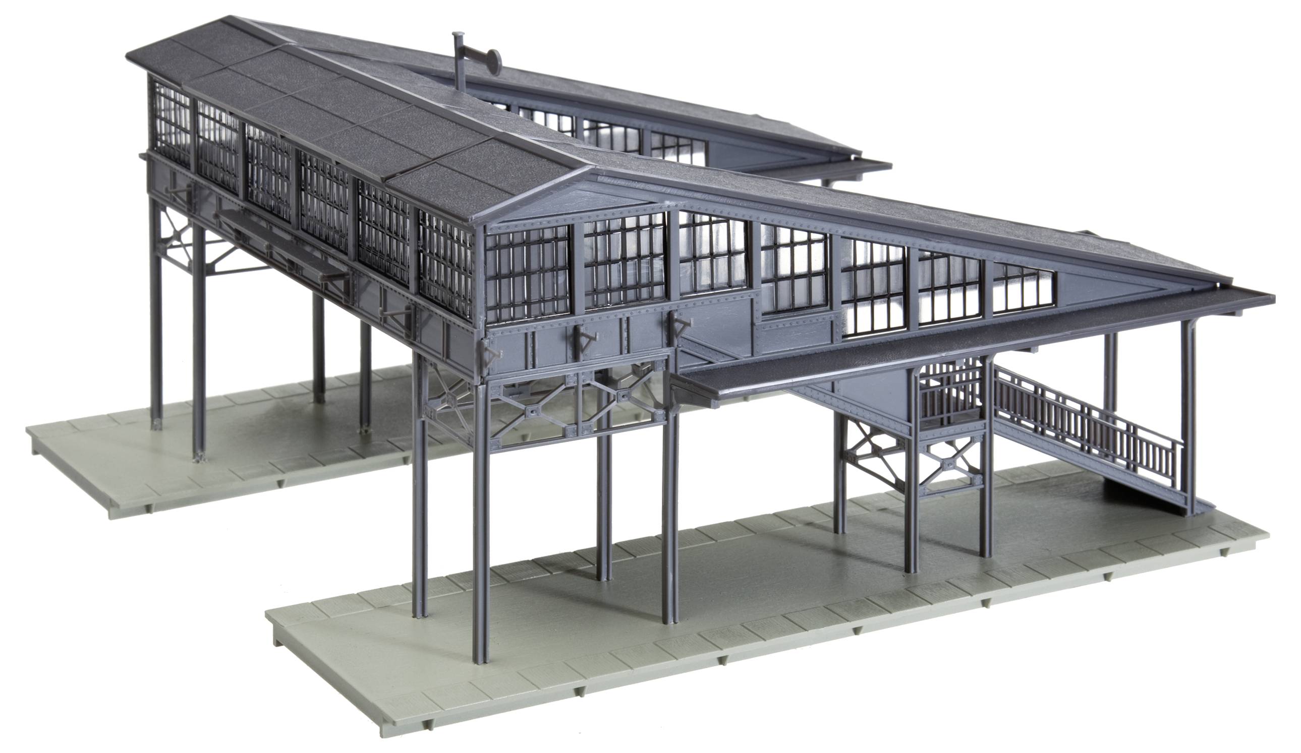 Model of a modern railway station building with large glass windows situated on an elevated structure supported by metal pillars.