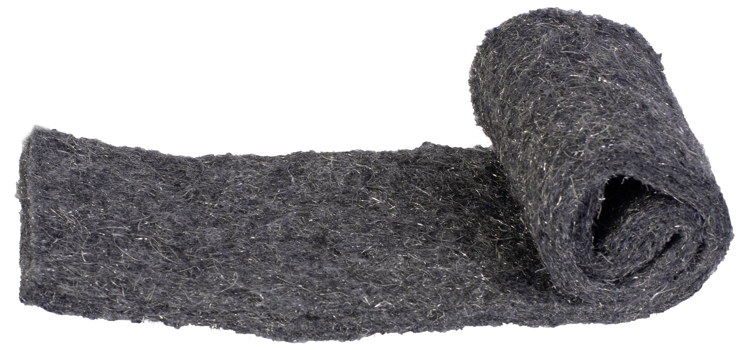 A roll of black, fluffy material, partially unrolled and lying on a white surface.
