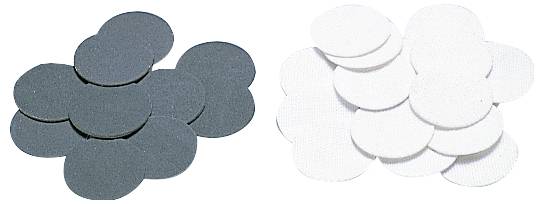 Black and white discs in two separate stacks, possibly used as grinding wheels or filter inserts.
