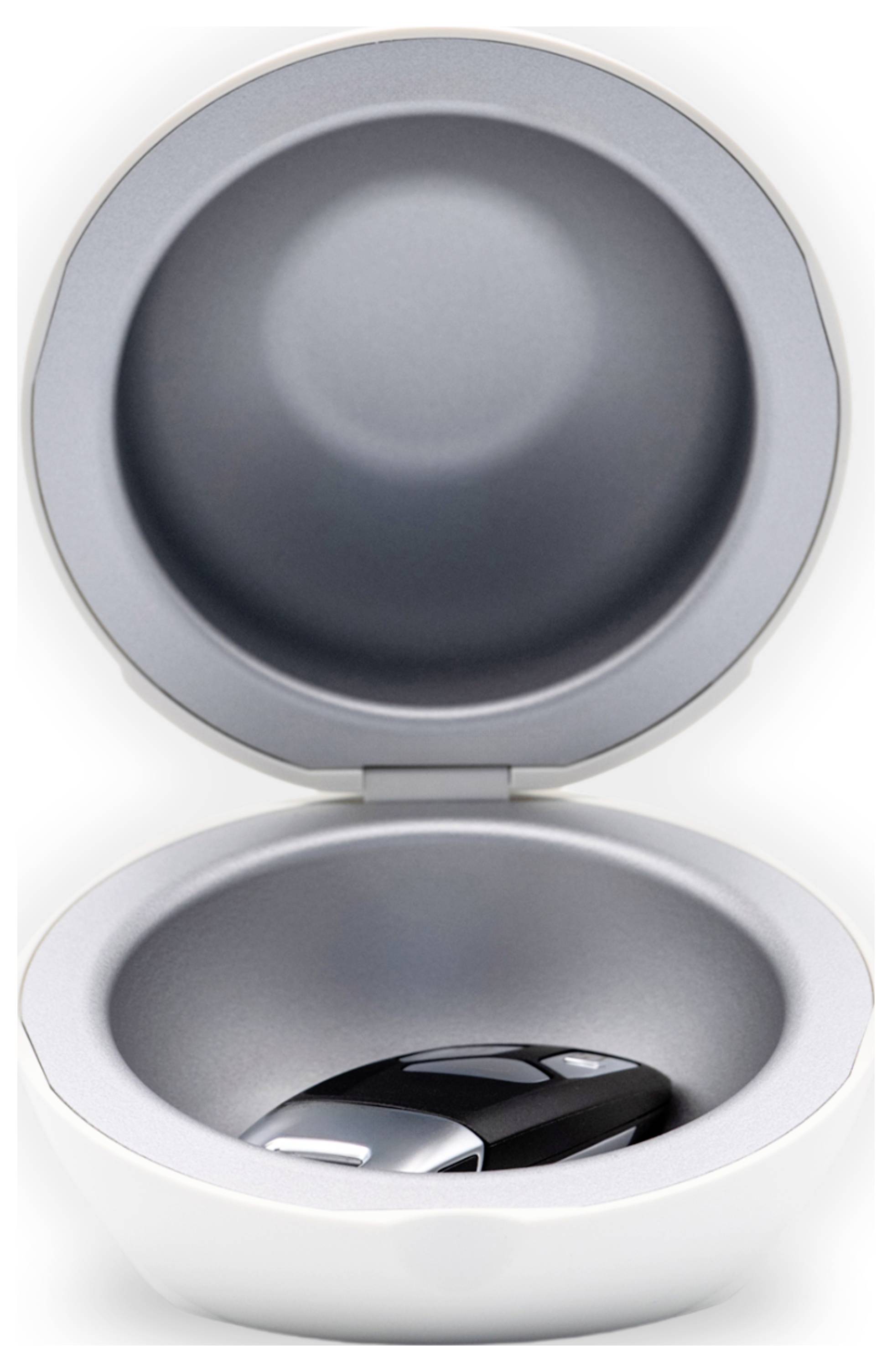 Round container with open lid, contains a black car key.