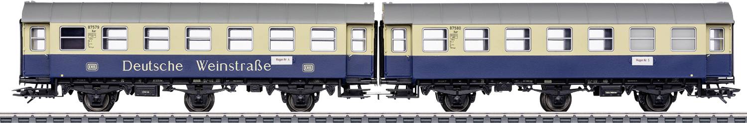 Two historic railway carriages with the inscription 'Deutsche Weinstraße', painted in blue and yellow, on a railway track.