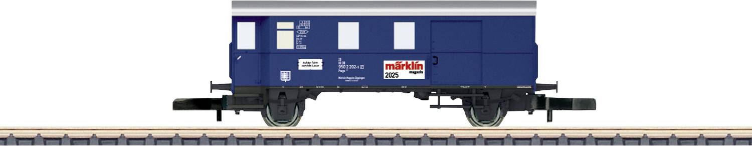 Blue goods wagon with 'Märklin' logo, standing on railway tracks.