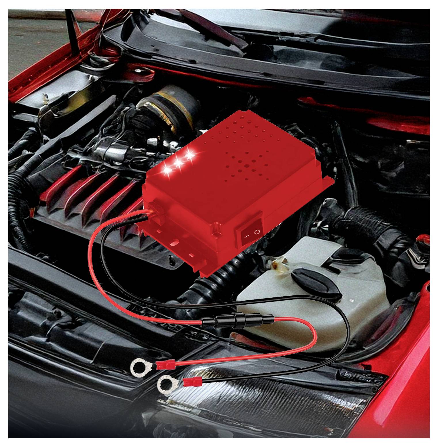 A car engine with a red electronic device connected to the battery, likely used for diagnostics or power management.