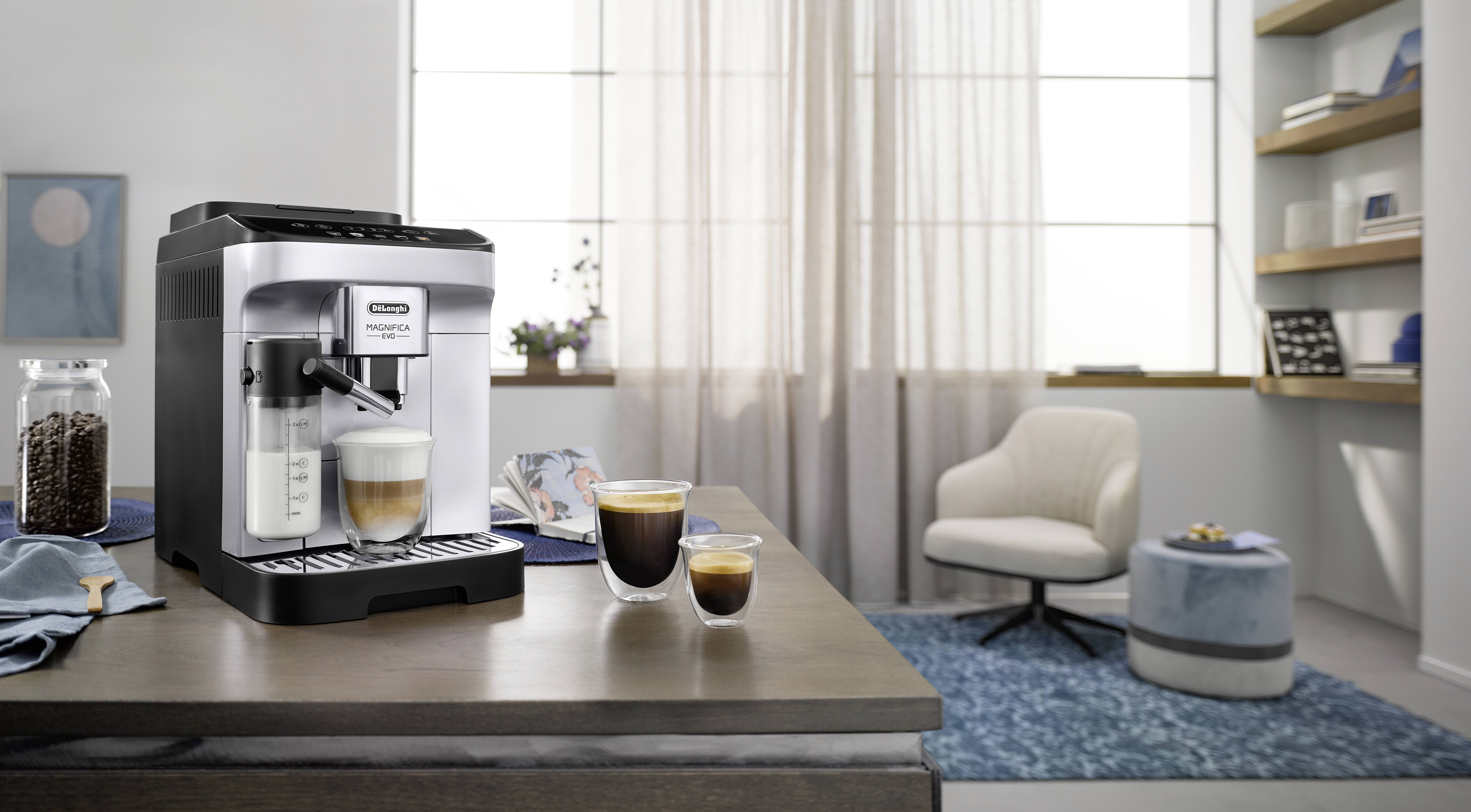 A modern espresso coffee machine on a kitchen counter with two fresh cups of coffee beside it, in a bright, cozy kitchen setting.