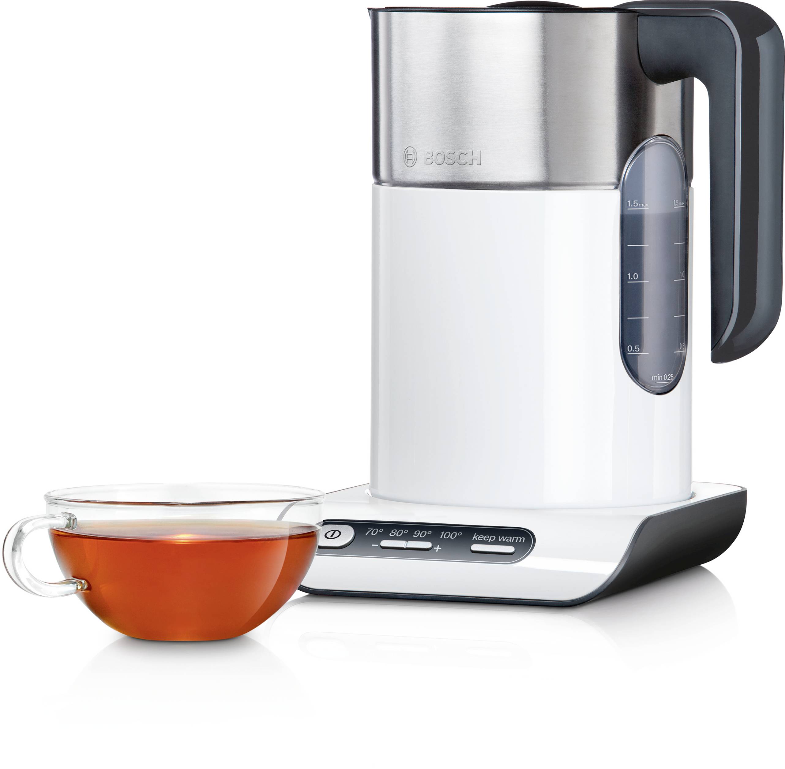 Electric kettle with temperature settings and a glass cup of tea beside it. The kettle is white with a digital display on its base.