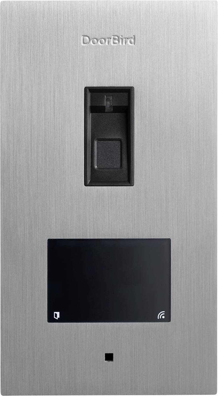 A metallic DoorBird intercom panel with a camera at the top and a screen below, used for building access and visitor communication.