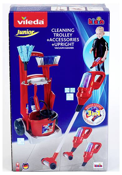 Box featuring a red cleaning trolley with accessories, including a mop, broom, and vacuum cleaner. Child in the background holding a toy vacuum.
