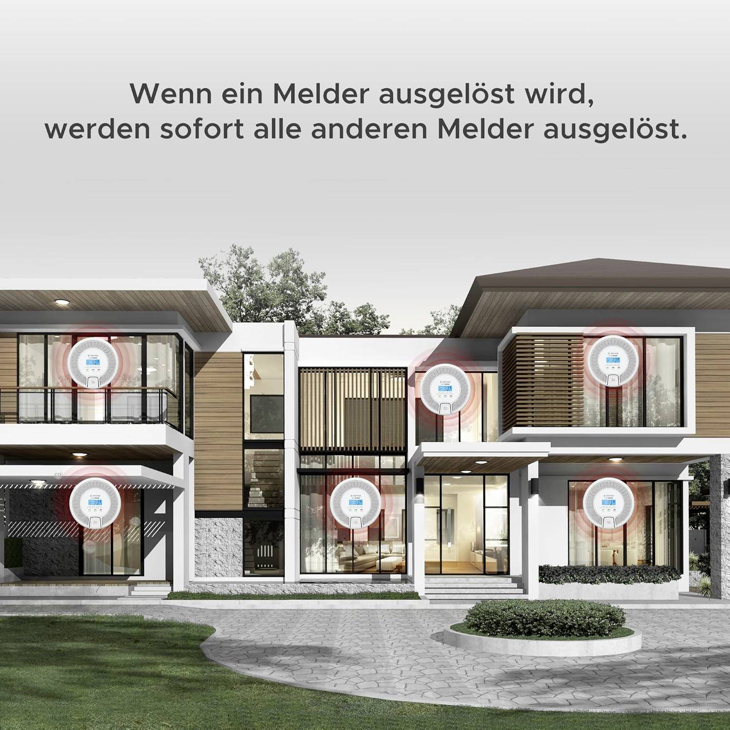 A modern two-storey house with multiple smoke detectors on the façade. Text above: 'If one detector is triggered, all other detectors are immediately triggered.'