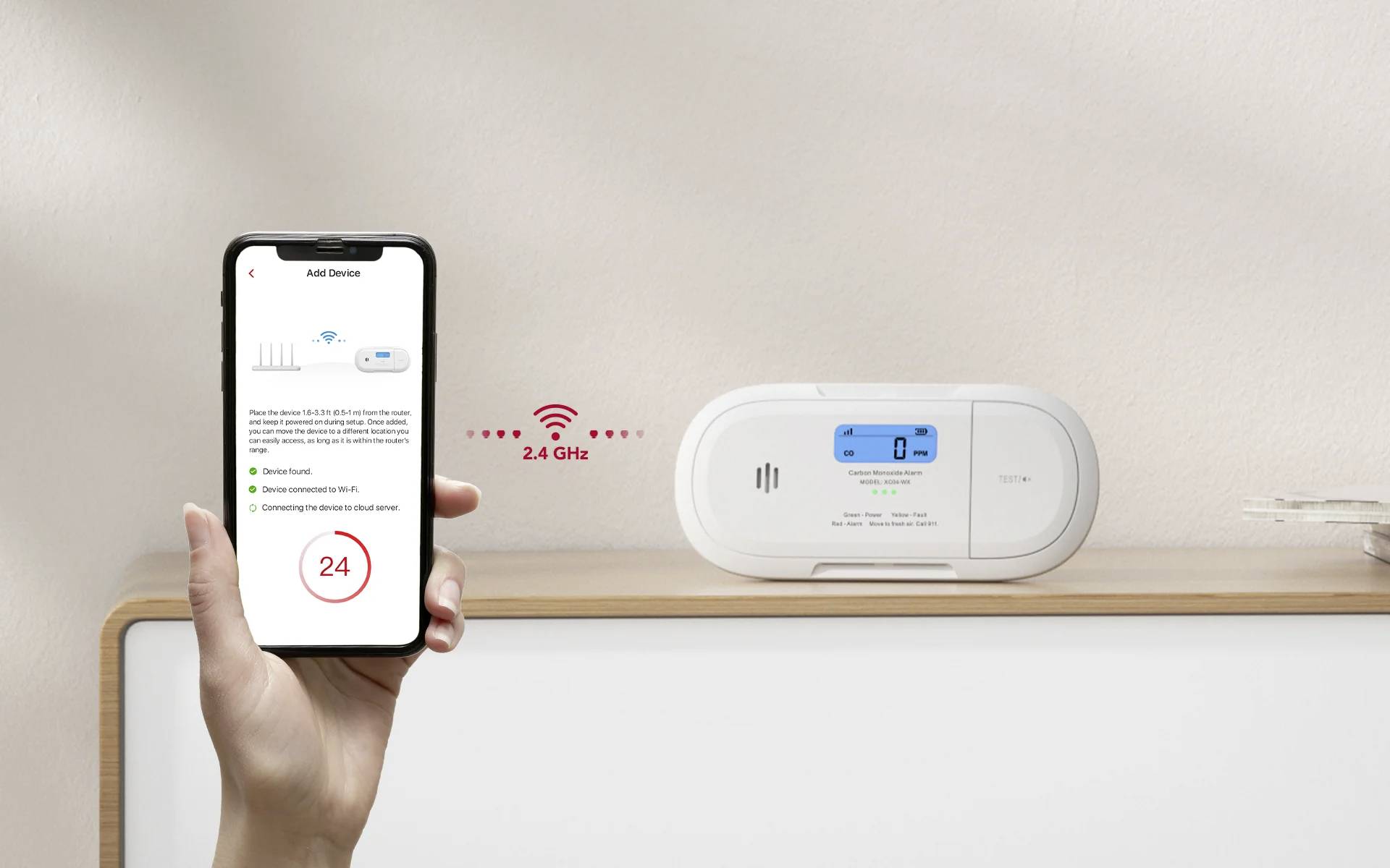 A hand holds a smartphone showing a smart home app screen. Nearby, a smart home device with a digital display shows a blue screen. Wi-Fi icon indicates 2.4 GHz connection.