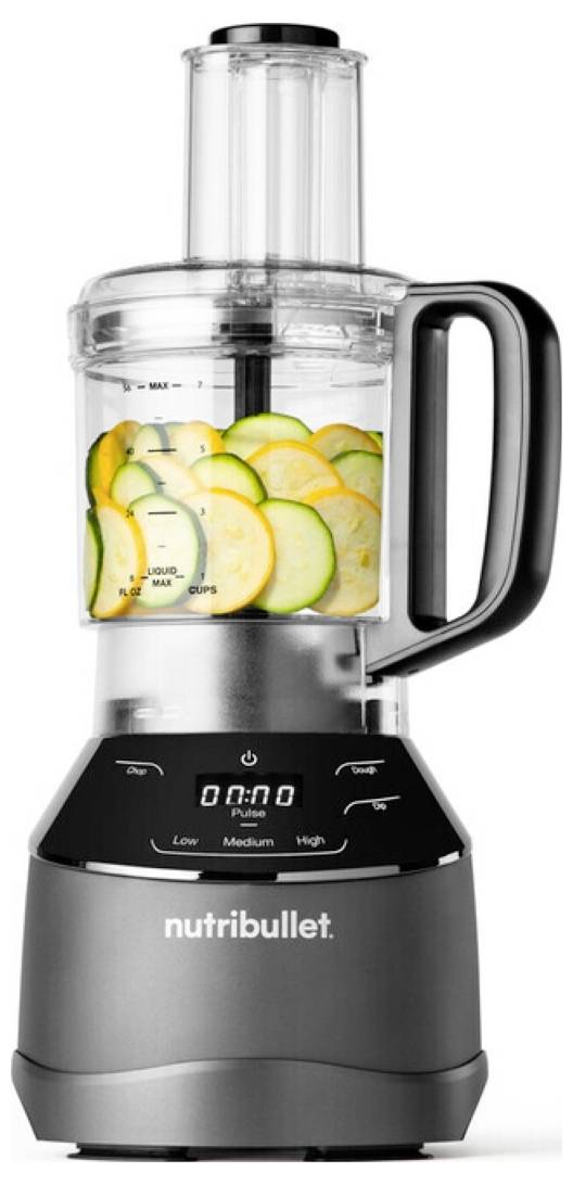 Nutribullet food processor with clear container, digital timer, and handle, filled with sliced zucchini and squash.