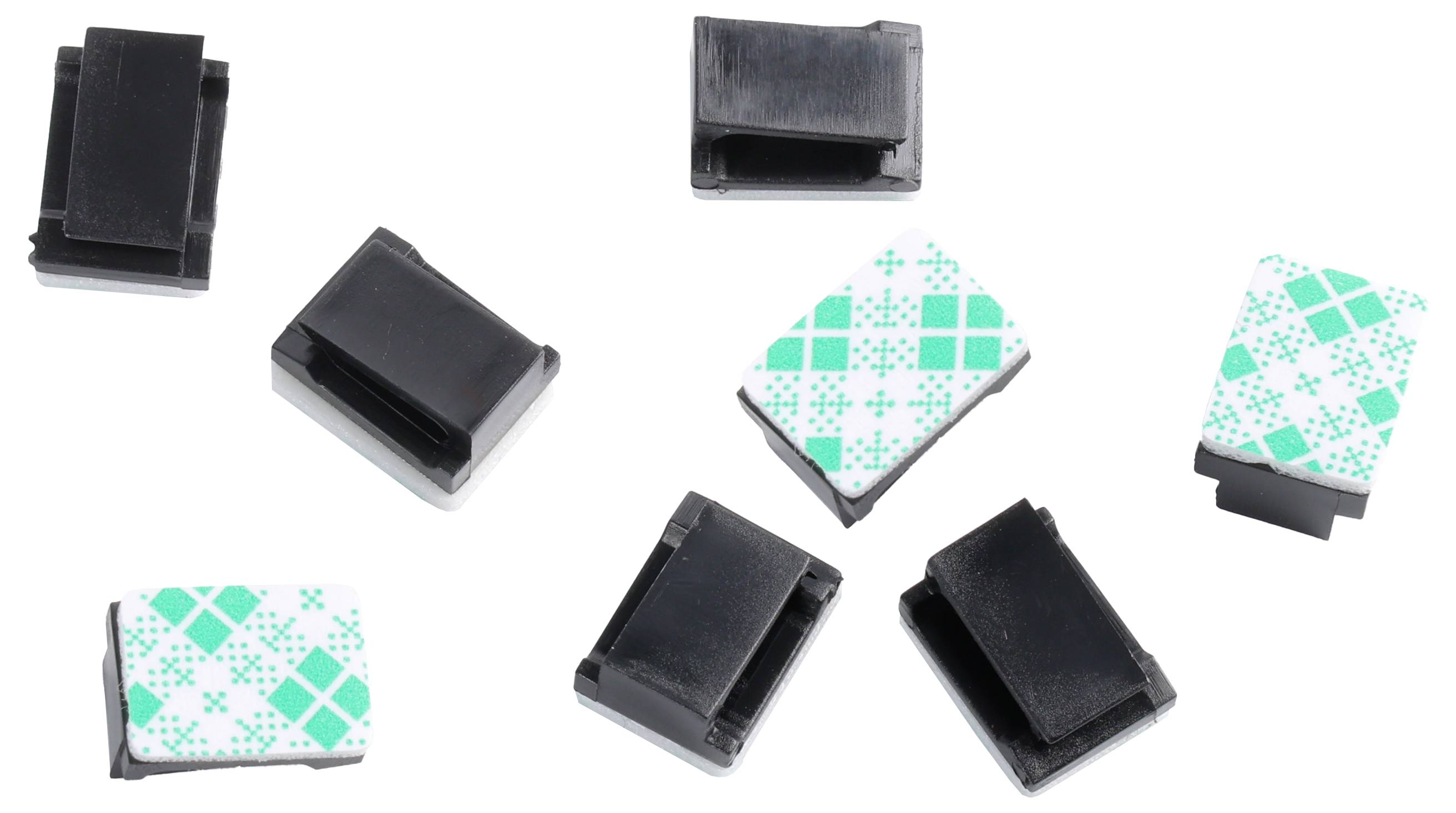 Scattered plastic cable clips, some black, some with green geometric patterns on white, used to organize cables and wires.