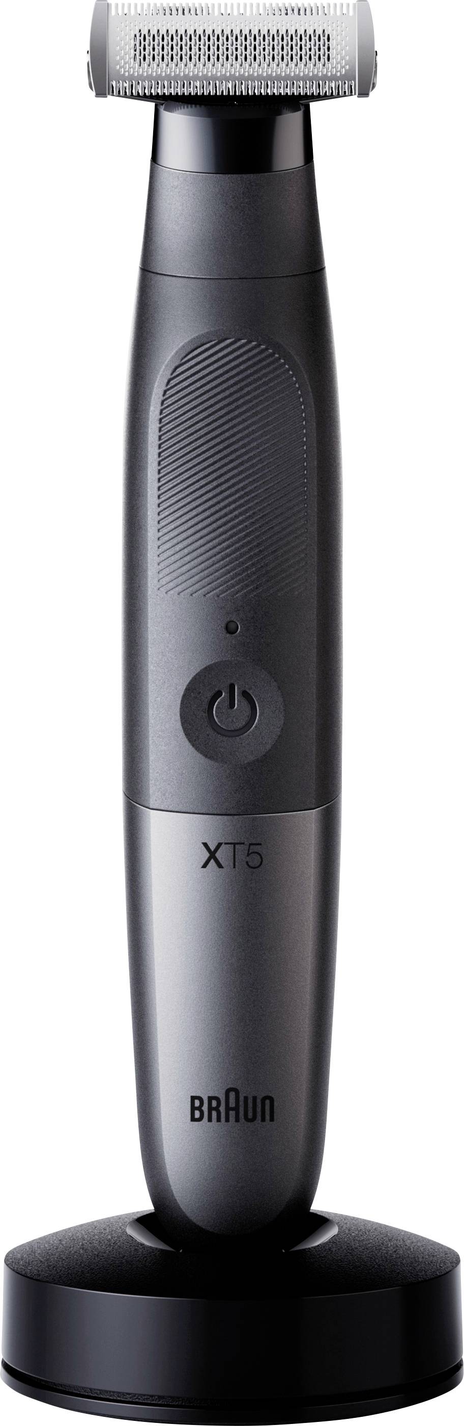 Electric grooming tool with a sleek black handle, power button in the center, and 'XT5' branding on the front. It rests on a stand.