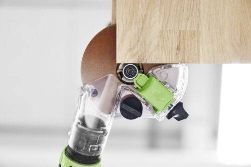 A power tool with a green motor sands the edge of a wooden surface, showcasing its function in woodworking or furniture making.