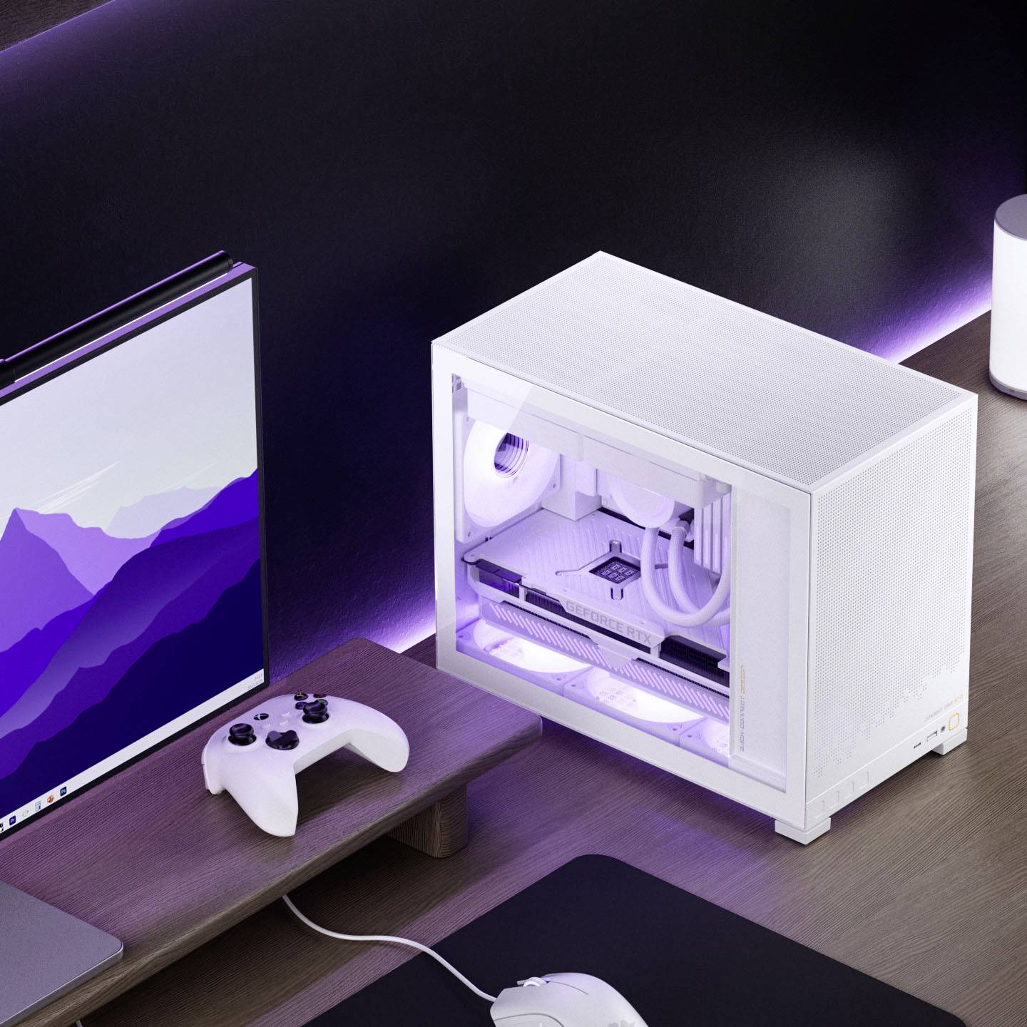 A white desktop computer with side LED lights is on a clean desk near a monitor displaying a purple mountain graphic and a game controller.