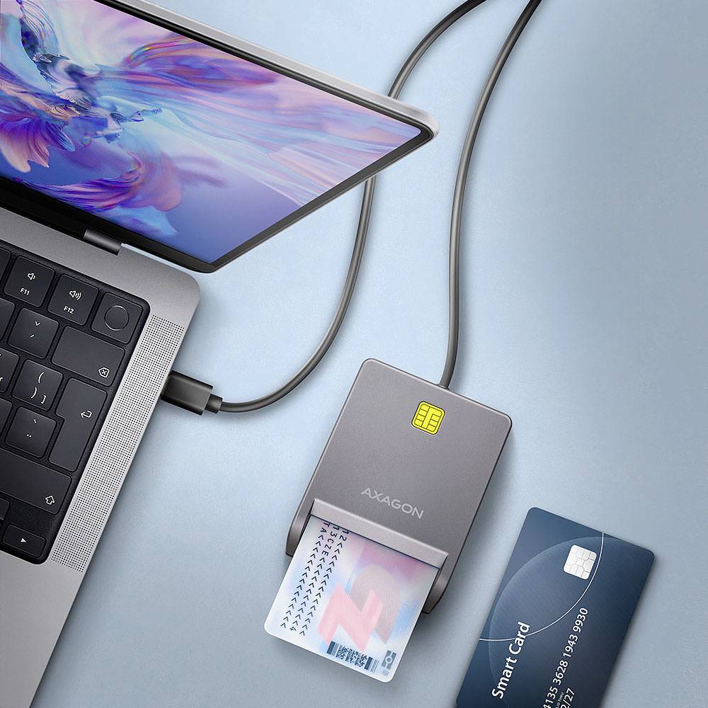 A laptop connects to a card reader with a card inserted, next to a smart card.