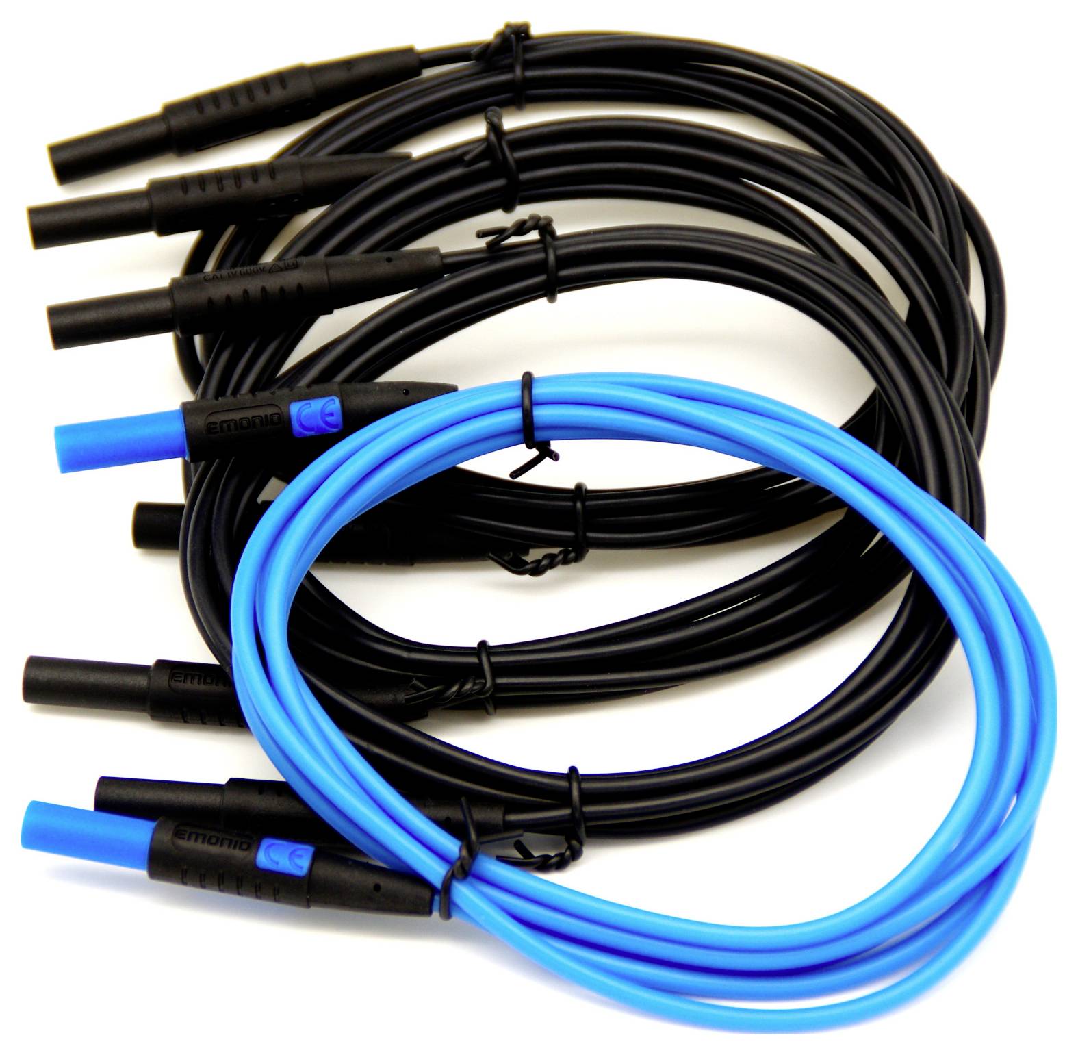 A set of electrical test leads: four black and one blue, with banana plug connectors, coiled and arranged flat against a white background.