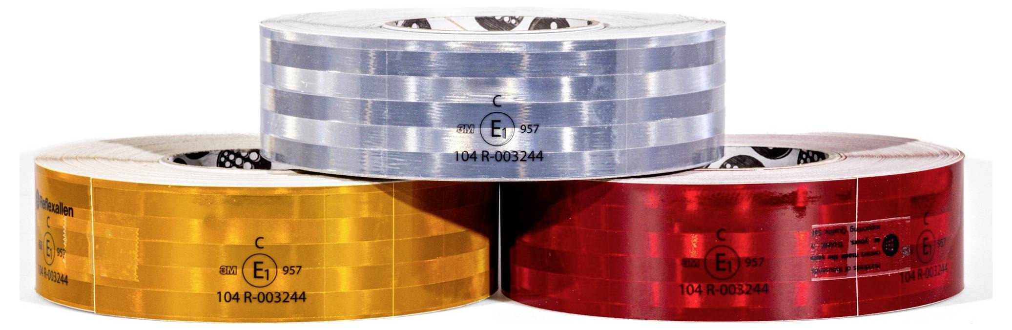 Three rolls of reflective tape in silver, yellow, and red colors stacked together, used for marking or visibility enhancement.