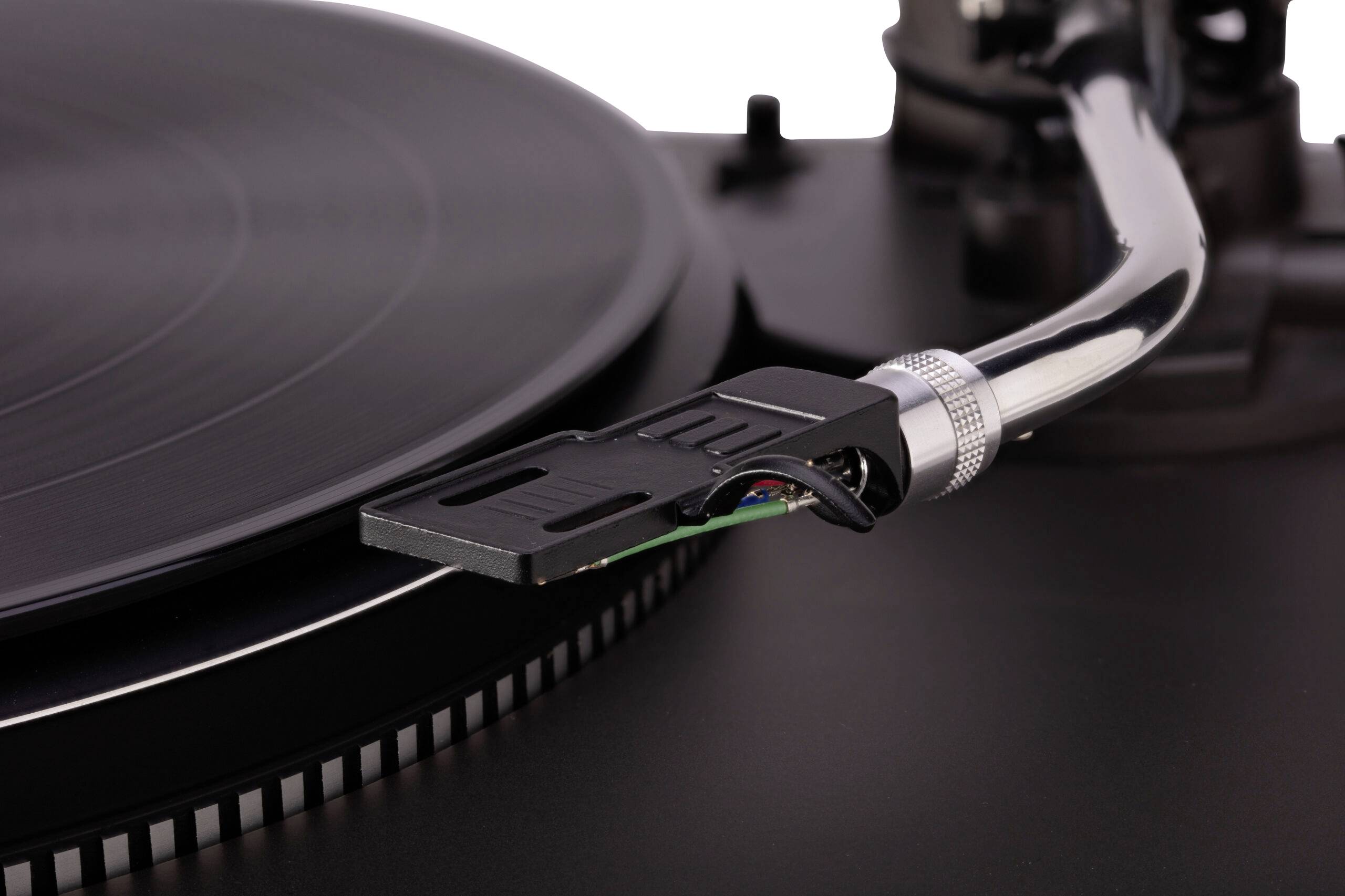 A close-up of a vinyl record player with a tonearm stylus positioned on a spinning black vinyl record.