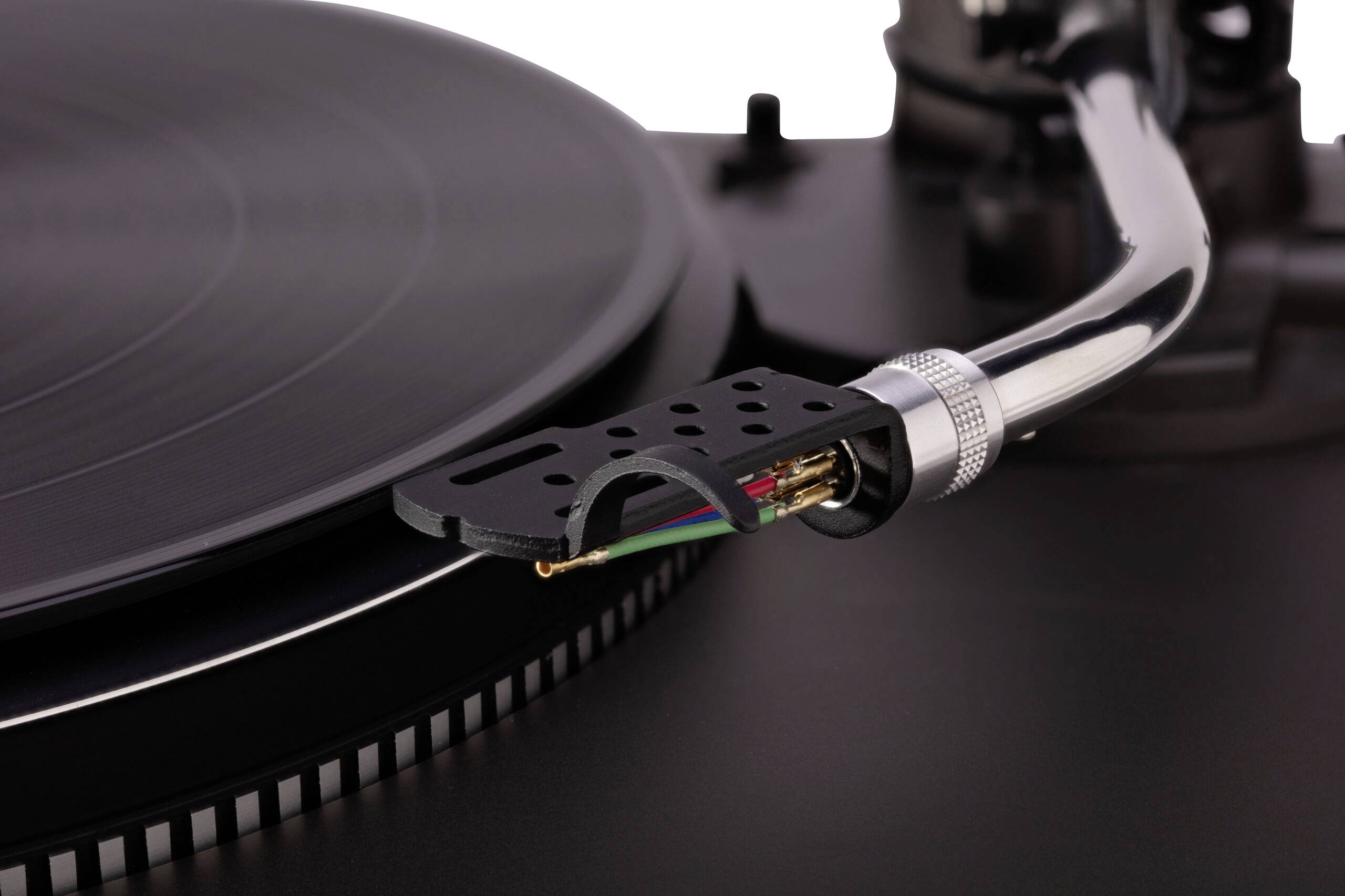A close-up of a vinyl turntable's tonearm and needle hovering over a spinning record, showcasing details of the grooves and components.