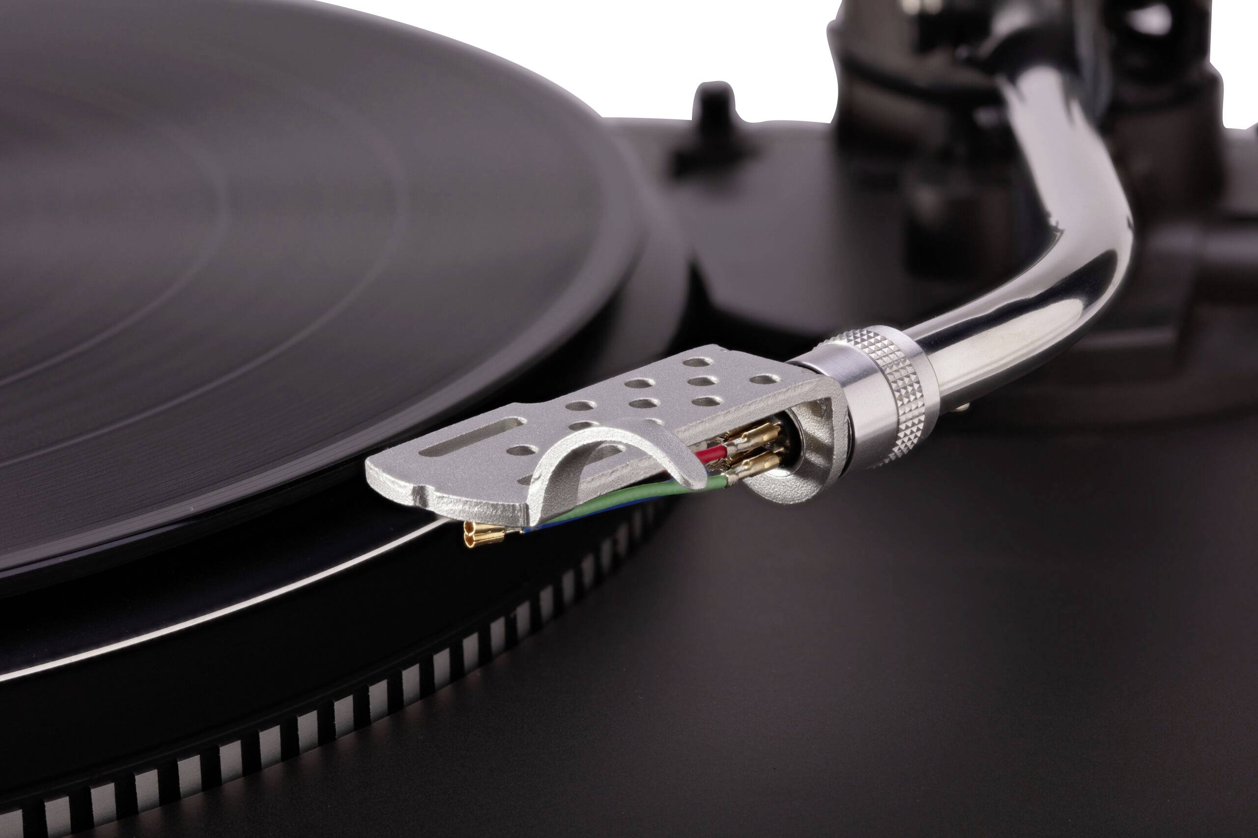 Close-up of a turntable's tonearm and needle positioned over a spinning vinyl record, indicating the playing of music.