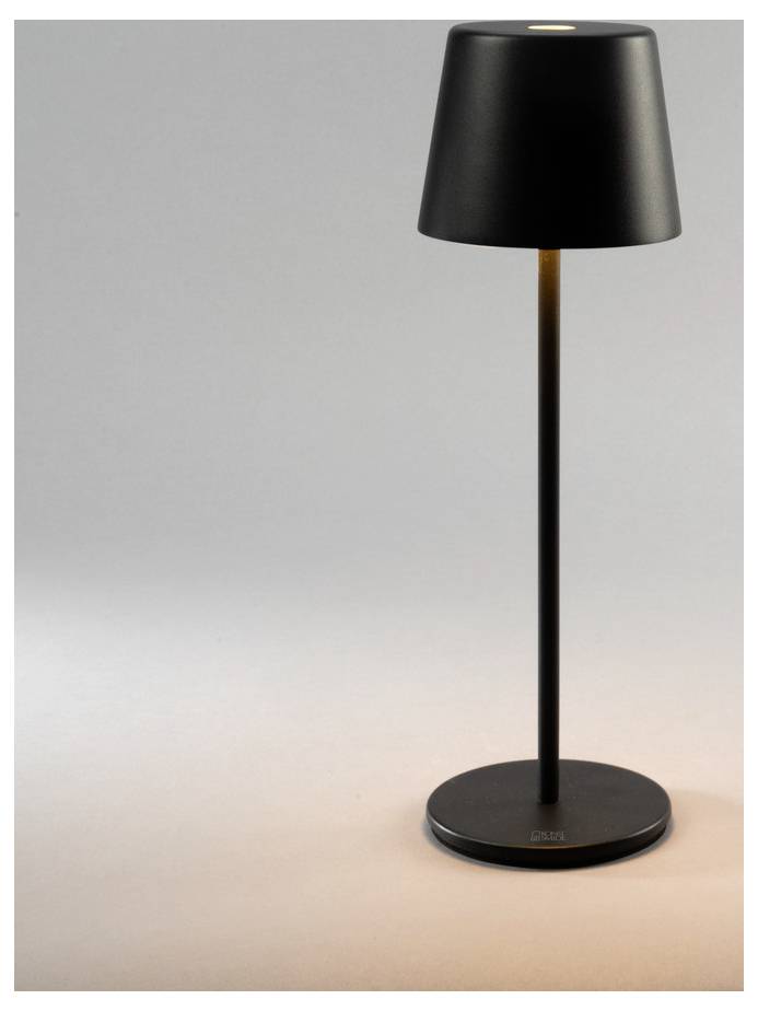 A sleek, modern black table lamp with a conical shade casts a warm light onto a minimalistic gray background.
