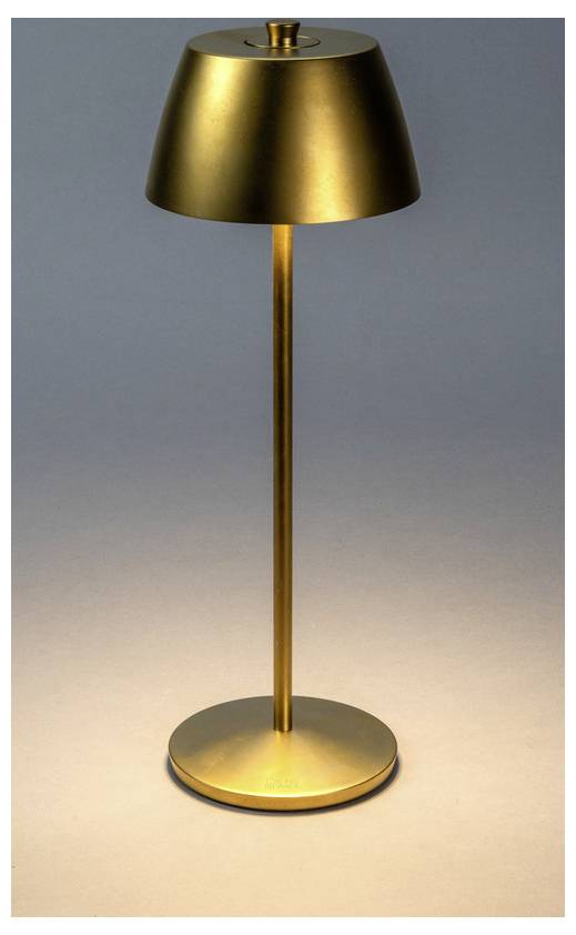 A sleek, modern, gold-toned table lamp with a cylindrical base and conical shade, casting a warm glow on a light-colored surface.