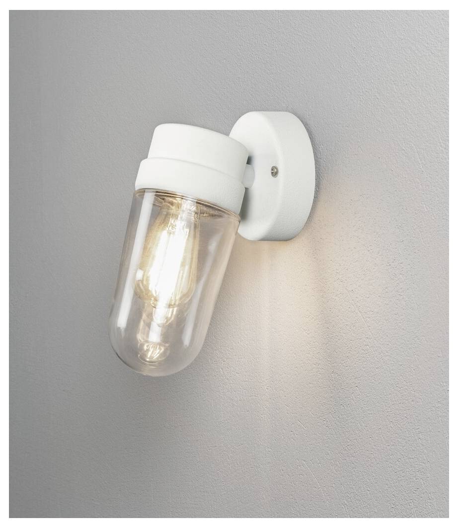 A white wall-mounted light fixture with a visible bulb inside a glass casing. It emits a warm glow onto the surrounding wall.