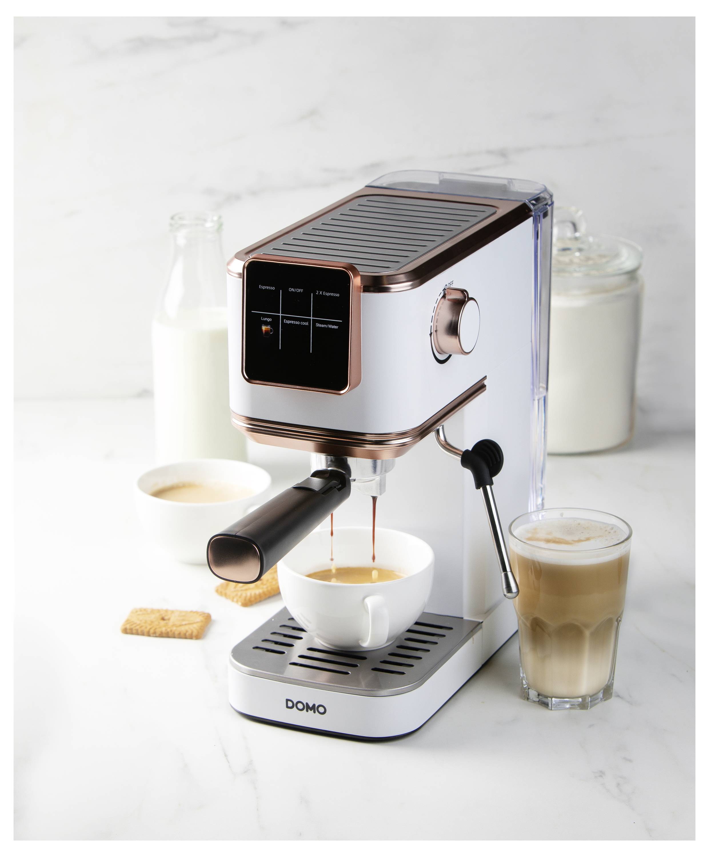 A home espresso machine brewing coffee into a cup, with milk and sugar nearby, a glass of latte to the side, and a biscuit in the background.