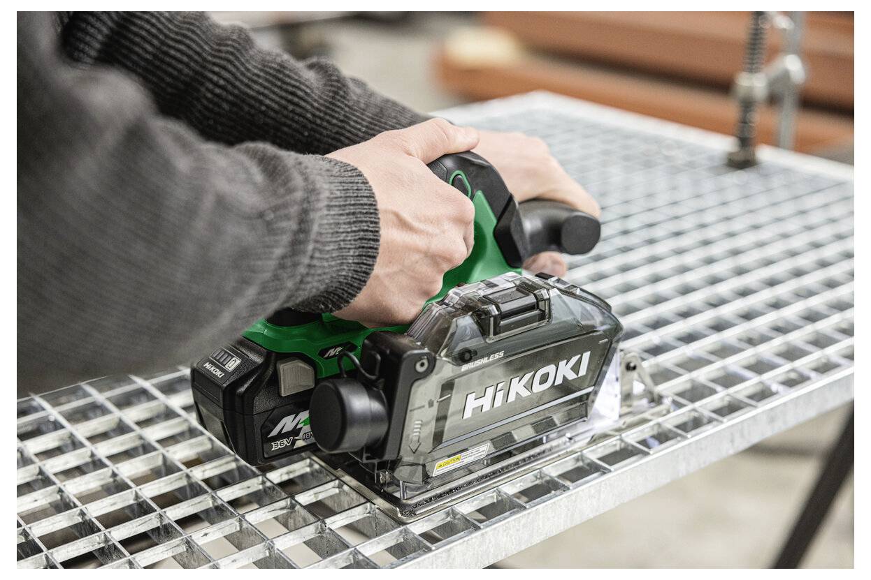 A person using a HiKOKI power tool on a metal grid surface. The tool is cordless and designed for construction or DIY work.