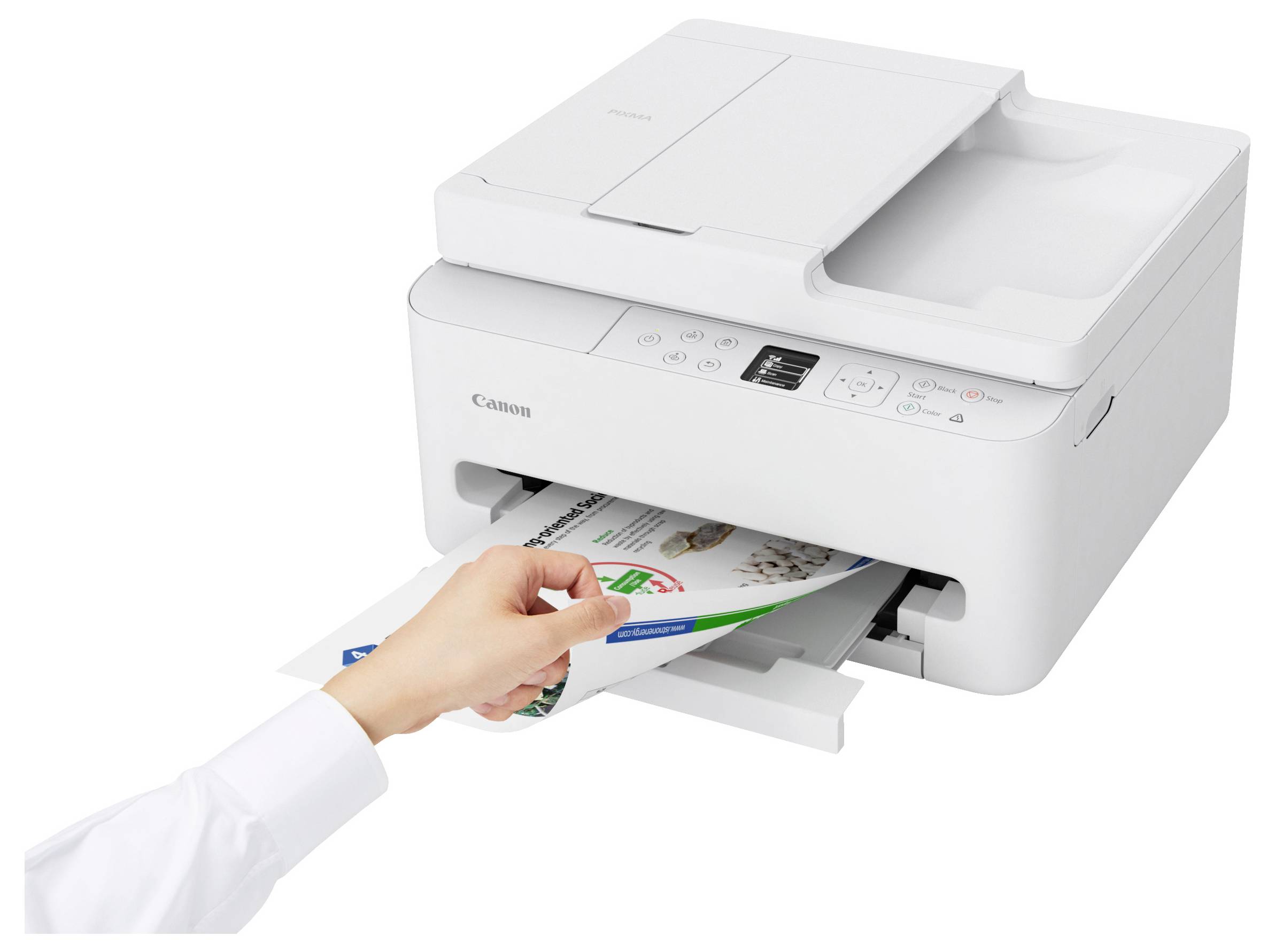 A person is removing a printed color document from a white Canon printer, highlighting printer functionality and user interaction.