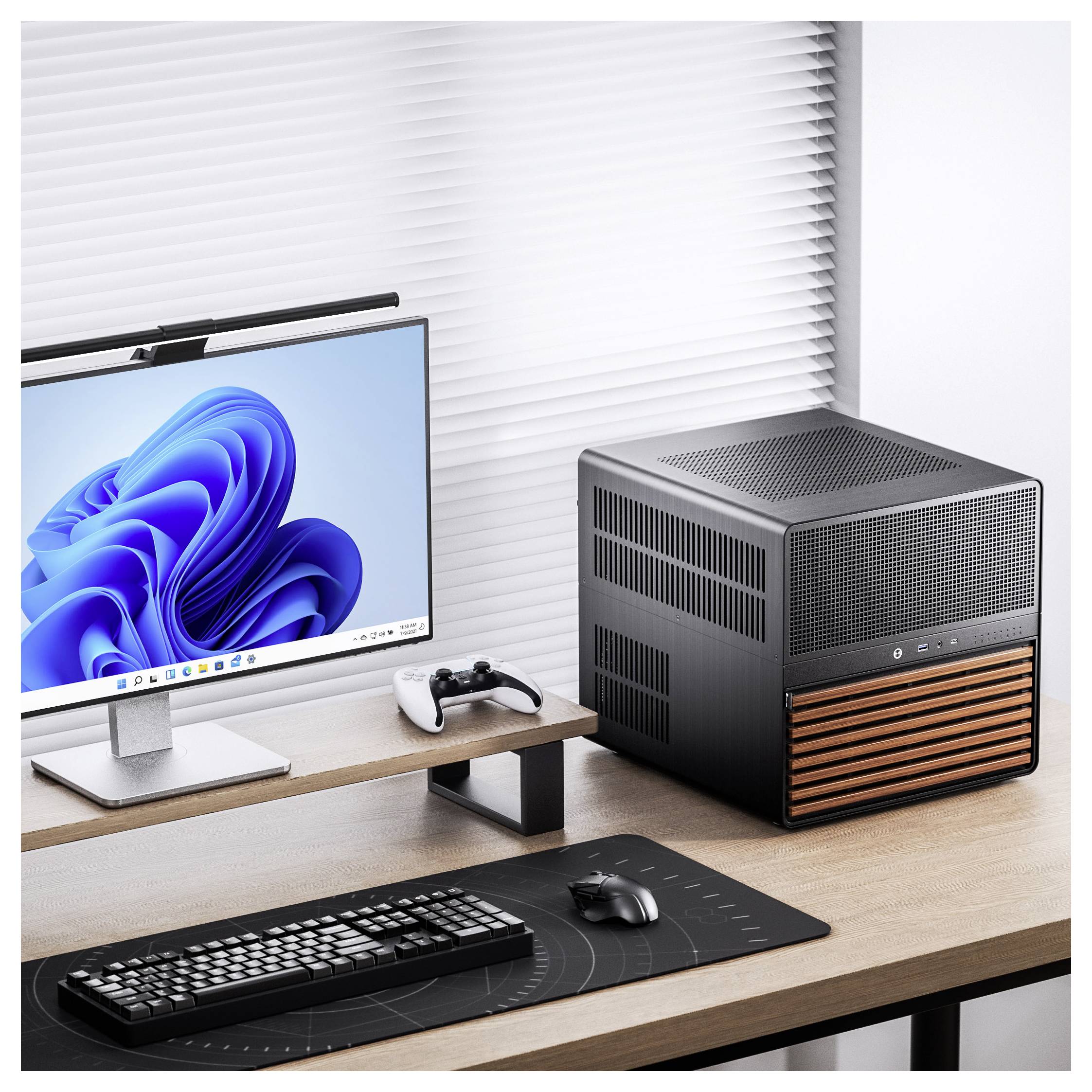 A modern desktop setup with a monitor displaying a blue swirl design, a mechanical keyboard, mouse, controller, and a sleek black computer case with wooden accents on a wooden desk.