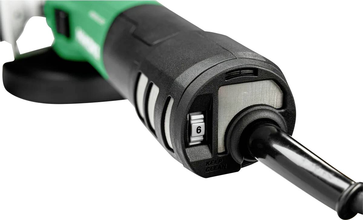 A green and black power tool with a focus on its adjustable dial set to number six, used for controlling speed or power settings.