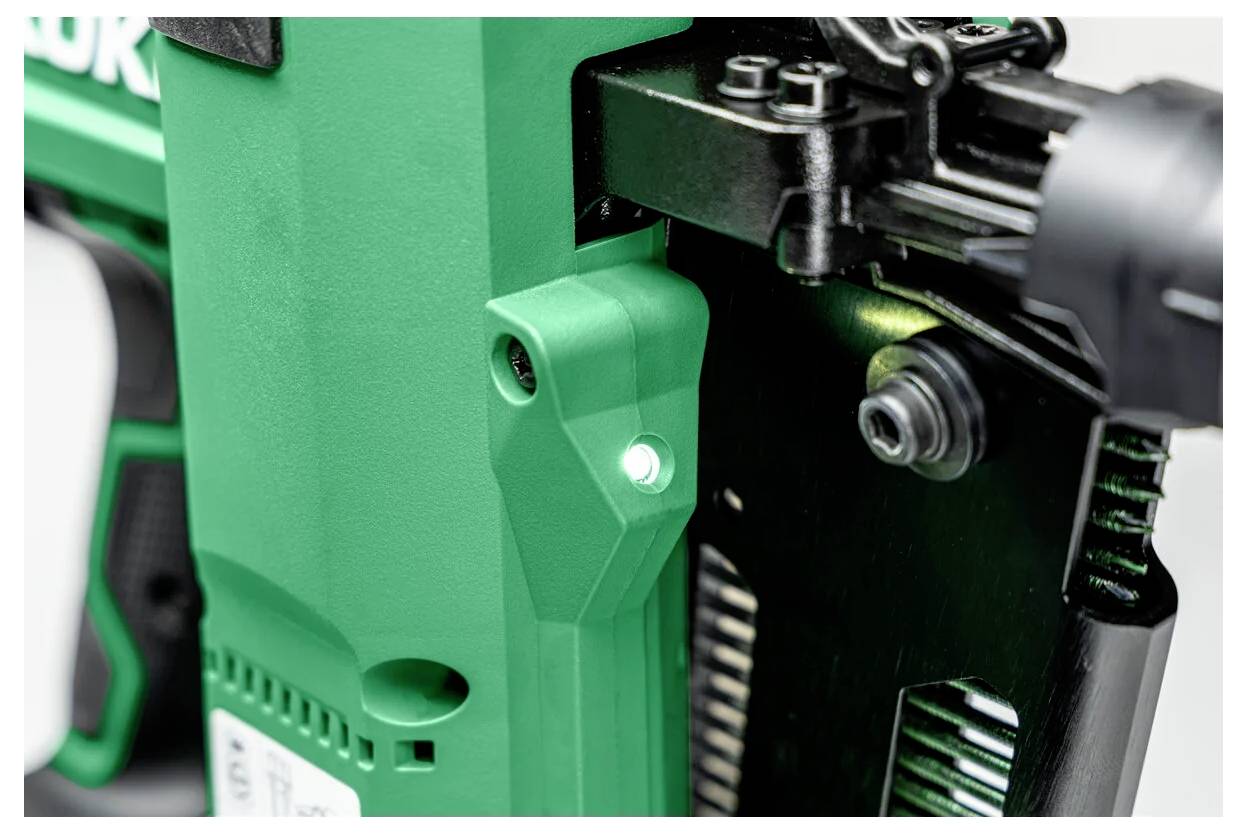 A close-up of a green power tool focusing on the trigger and handle section with black components visible.