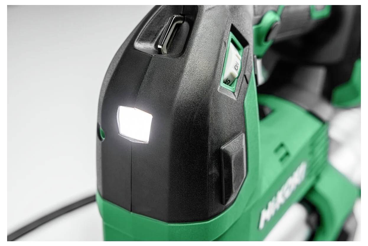 A green power tool with a lit LED light on the front, used for visibility in low-light conditions, featuring control buttons and ergonomic design.
