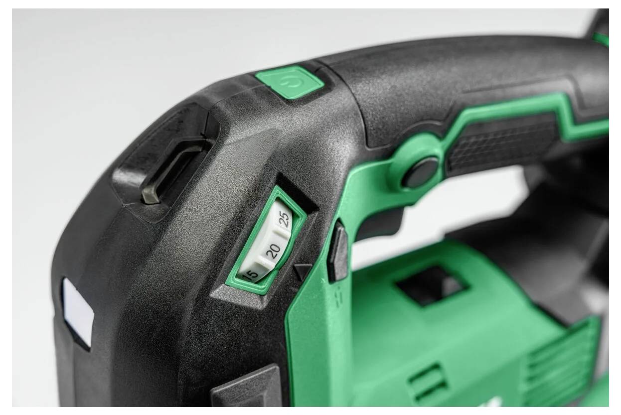 Close-up of a green and black power drill handle with a speed control dial showing numbers 15, 20, and 25 on the side.