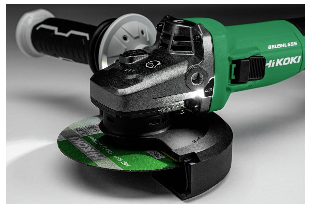 A green and black angle grinder with a side handle, labeled 'Brushless HiKOKI,' resting on a surface with a green disc attached.
