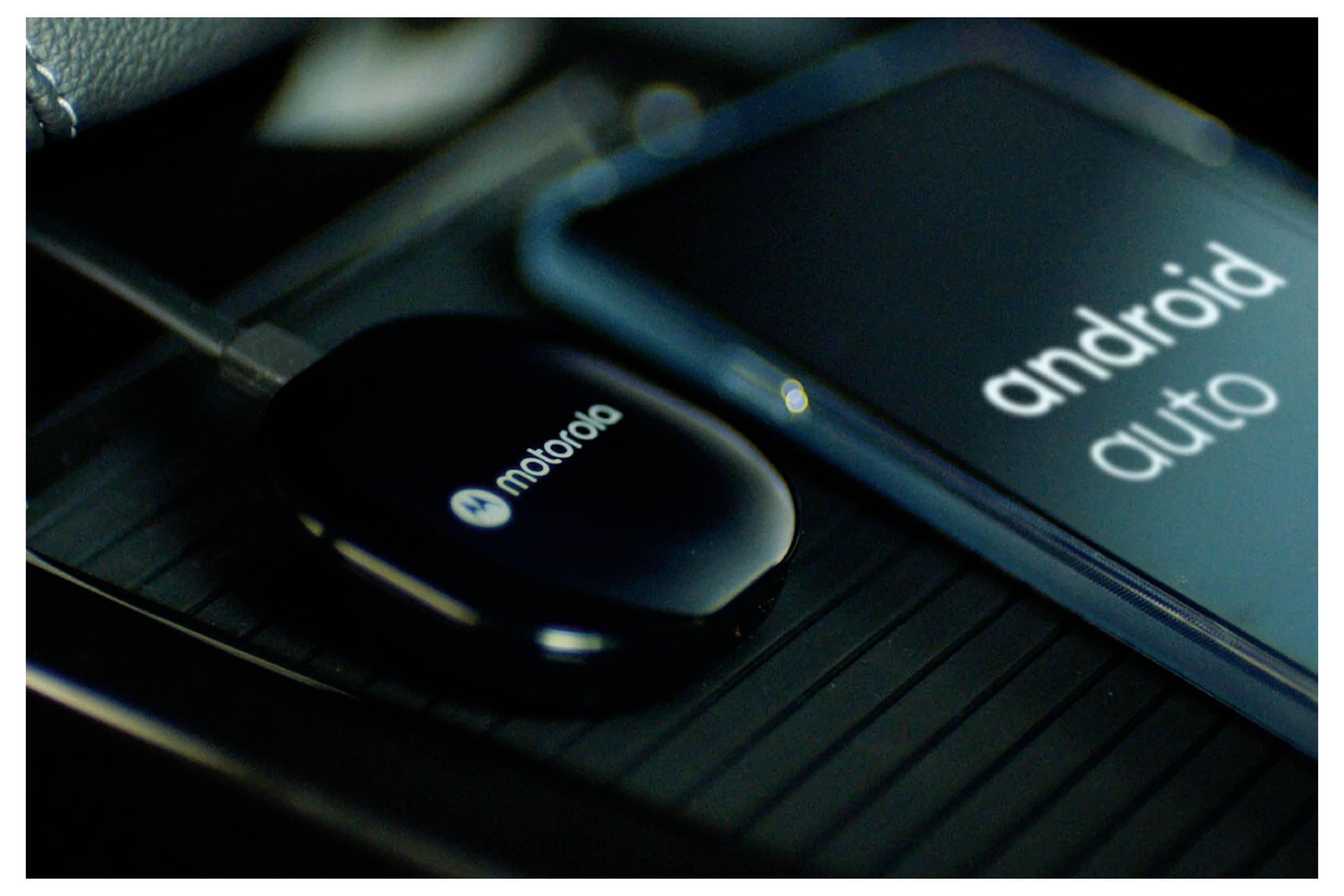 A Motorola device connected to a blue phone displaying 'android auto', likely indicating wireless connectivity or app usage in a car.