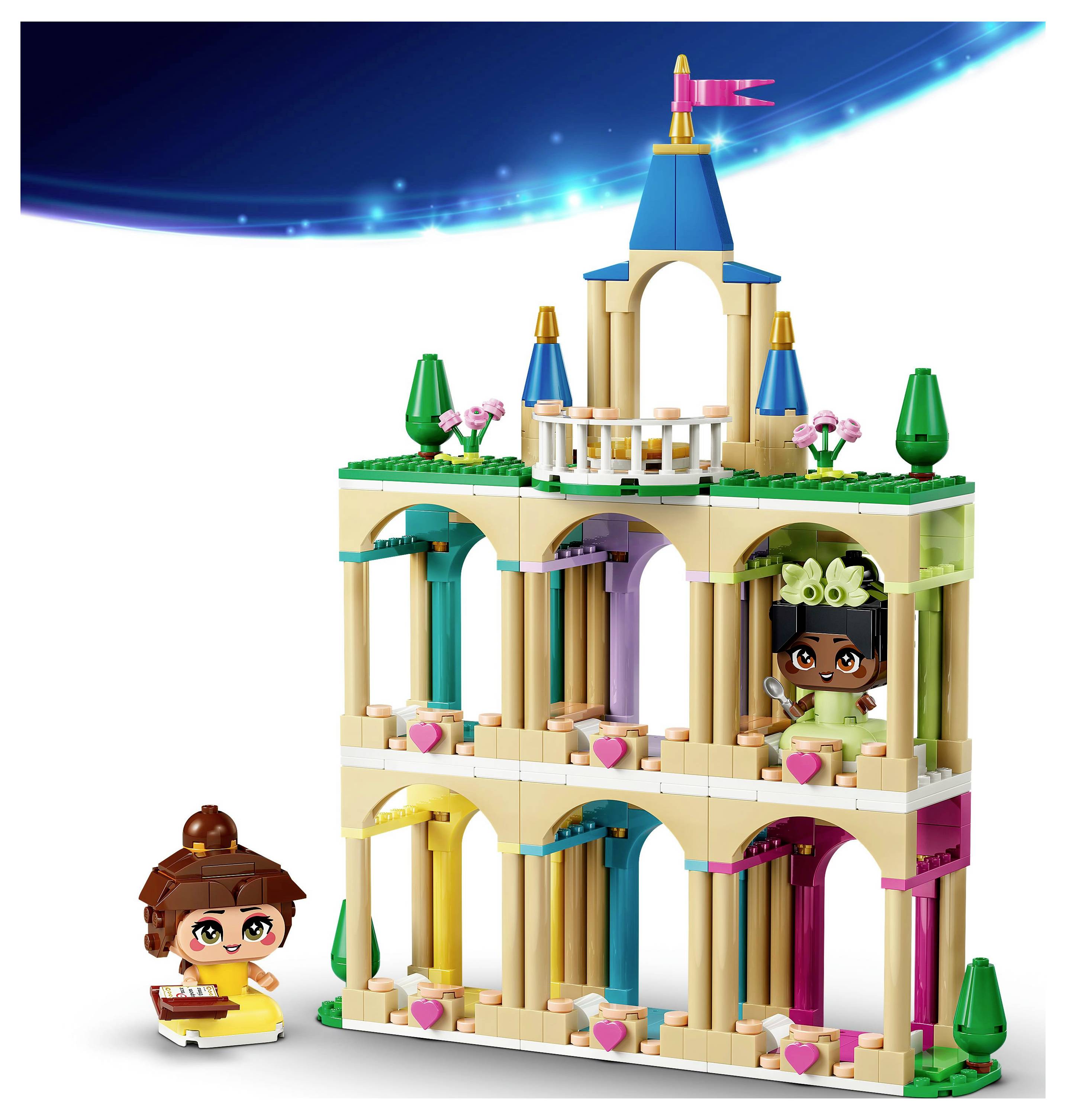A colorful toy castle built from interlocking blocks features multiple arches and balconies. Two toy figurines, one with a book, are present.